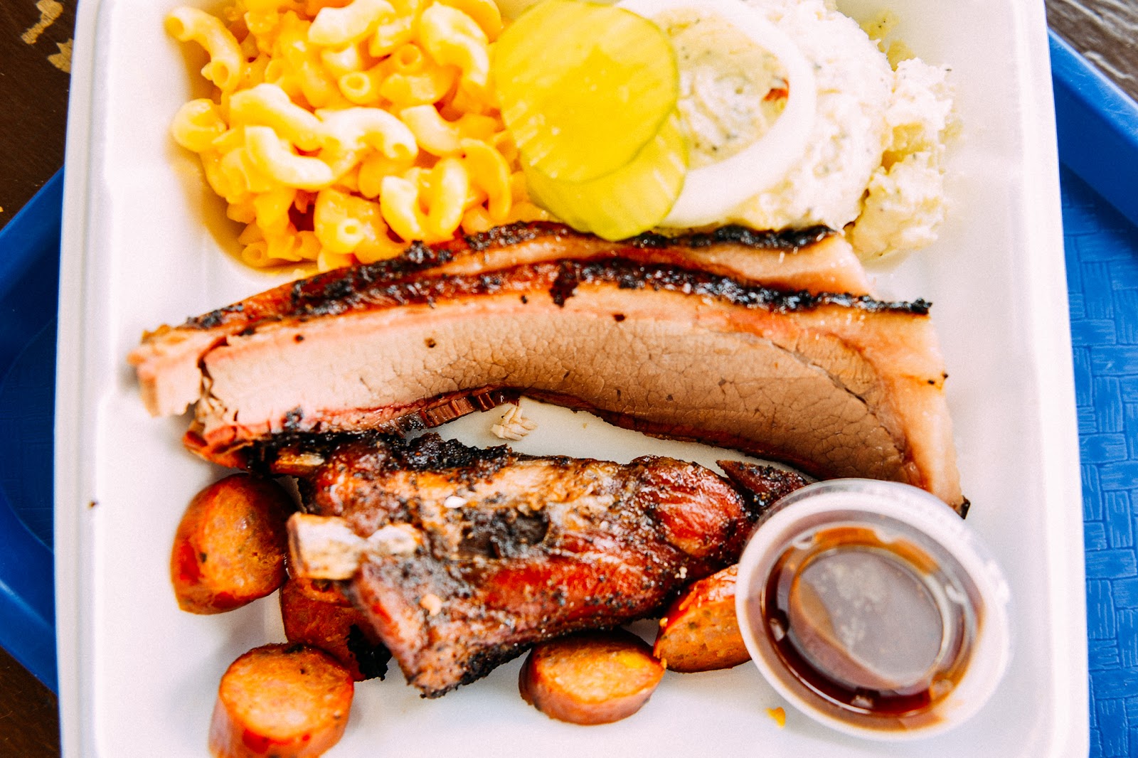 Barbecue plate with ribs, brisket, sausage, mac and cheese and potato salad