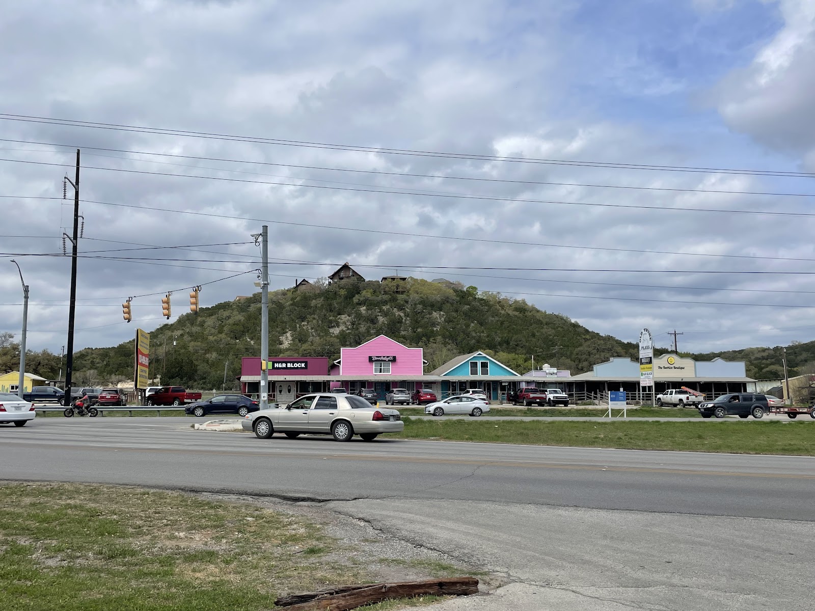 Exterior of The ReaL Pit BBQ tin-roofed smokehouse with neon OPEN sign